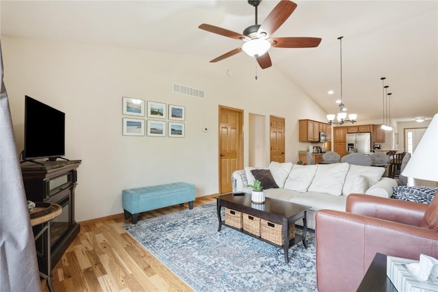 5752 Oakwood Ave NE Unit 3, Cedar Rapids, IA 52402 - living area with a ceiling fan, light wood finished floors, a chandelier, and high vaulted ceiling