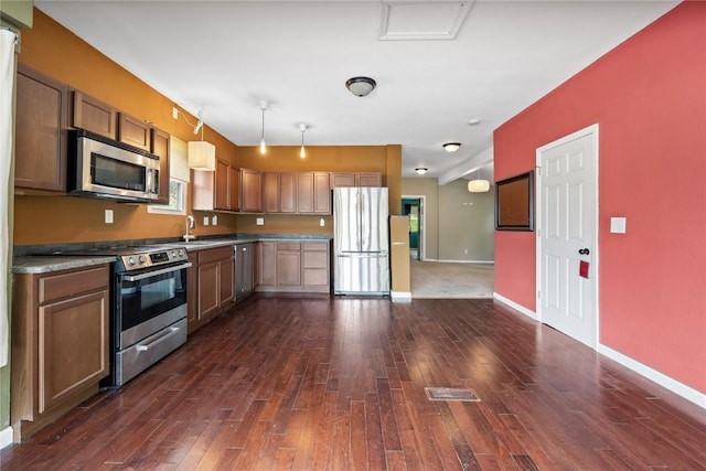 314 2nd St NW, Mount Vernon, IA 52314 - kitchen featuring appliances with stainless steel finishes, dark wood-style flooring, and hanging light fixtures