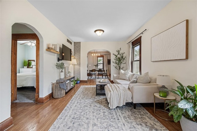 1307 8th St NW, Cedar Rapids, IA 52405 - living room featuring arched walkways, light wood-style floors, and a ceiling fan