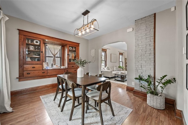 1307 8th St NW, Cedar Rapids, IA 52405 - dining area with arched walkways and light wood-style floors