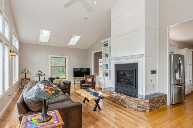 1916 Oak Knoll Ct SE, Cedar Rapids, IA 52403 - living area with light wood-style floors, a skylight, a glass covered fireplace, ceiling fan, and high vaulted ceiling