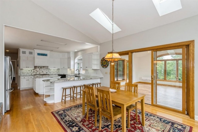1916 Oak Knoll Ct SE, Cedar Rapids, IA 52403 - dining space with a skylight, light wood-type flooring, lofted ceiling, and a chandelier