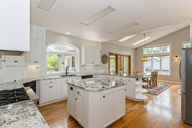 1916 Oak Knoll Ct SE, Cedar Rapids, IA 52403 - kitchen with freestanding refrigerator, a peninsula, decorative backsplash, a center island, and white cabinetry