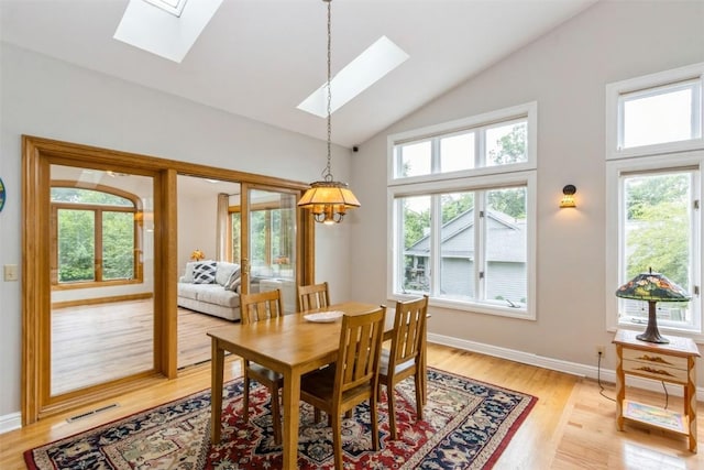 1916 Oak Knoll Ct SE, Cedar Rapids, IA 52403 - dining space featuring a skylight, plenty of natural light, light wood-style flooring, and high vaulted ceiling