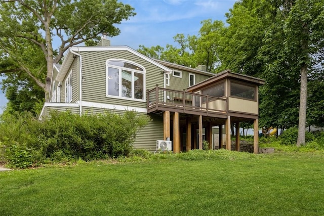 1916 Oak Knoll Ct SE, Cedar Rapids, IA 52403 - back of house with a chimney, a deck, a yard, and a sunroom