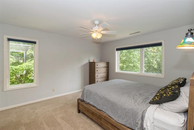 1916 Oak Knoll Ct SE, Cedar Rapids, IA 52403 - bedroom with multiple windows, light carpet, and ceiling fan