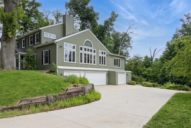 1916 Oak Knoll Ct SE, Cedar Rapids, IA 52403 - view of front of house featuring an attached garage, a chimney, driveway, and a front yard