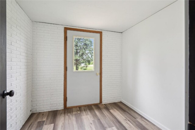 5995 32nd Ave, Shellsburg, IA 52332 - unfurnished room featuring brick wall and wood finished floors