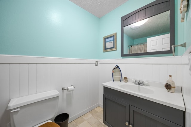 215 40th St Dr SE Unit 301, Cedar Rapids, IA 52403 - bathroom with a textured ceiling, vanity, and a wainscoted wall