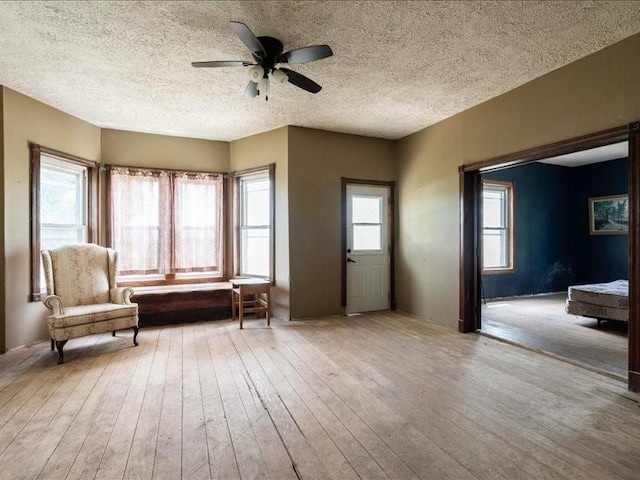 1931 140th St, Lowden, IA 52255 - living area featuring hardwood / wood-style flooring, a ceiling fan, and a textured ceiling