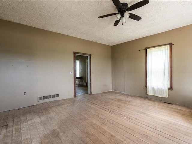 1931 140th St, Lowden, IA 52255 - empty room featuring hardwood / wood-style floors, a ceiling fan, and a textured ceiling