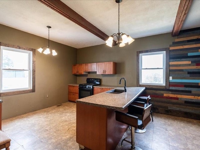 1931 140th St, Lowden, IA 52255 - kitchen with black range oven, a chandelier, beam ceiling, plenty of natural light, and a kitchen bar