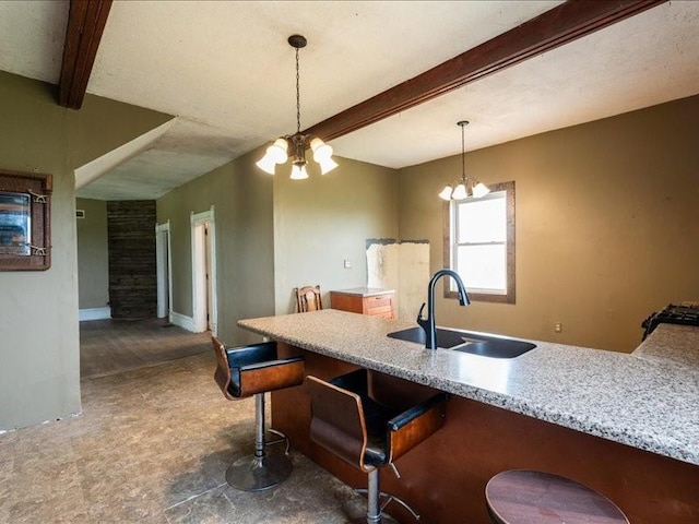 1931 140th St, Lowden, IA 52255 - kitchen with beamed ceiling, a chandelier, hanging light fixtures, a kitchen breakfast bar, and light stone counters