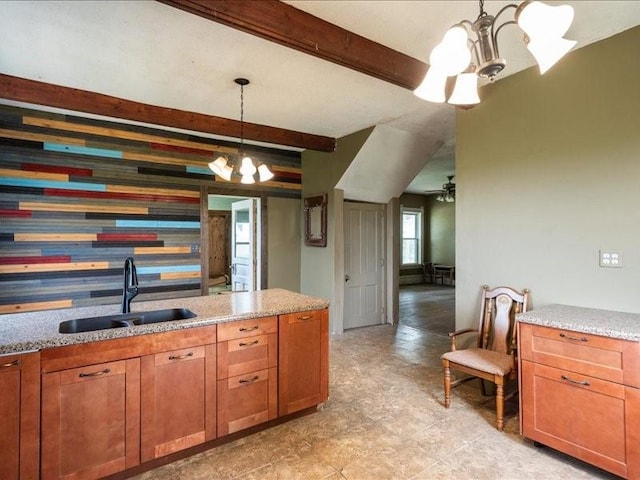 1931 140th St, Lowden, IA 52255 - kitchen with a chandelier, beam ceiling, light stone countertops, hanging light fixtures, and brown cabinets
