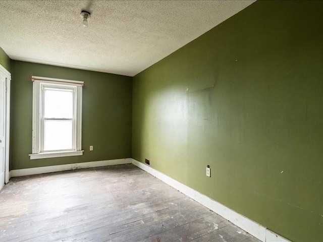 1931 140th St, Lowden, IA 52255 - empty room with wood-type flooring and a textured ceiling