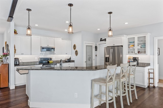 1062 Oak View Ct, Tipton, IA 52772 - kitchen featuring appliances with stainless steel finishes, dark wood-type flooring, recessed lighting, an island with sink, and glass insert cabinets