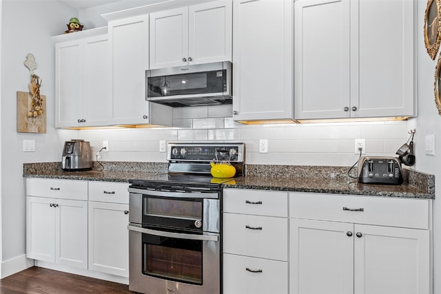 1062 Oak View Ct, Tipton, IA 52772 - kitchen featuring stainless steel appliances, white cabinets, backsplash, dark stone countertops, and dark wood-style flooring
