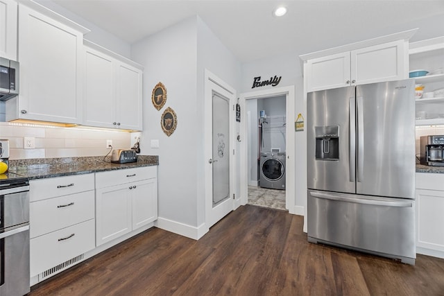 1062 Oak View Ct, Tipton, IA 52772 - kitchen featuring appliances with stainless steel finishes, washer / dryer, dark wood finished floors, dark stone countertops, and white cabinetry
