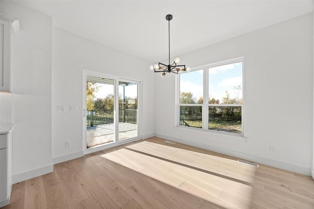 2682 Burr Oak Ct, Marion, IA 52302 - unfurnished dining area with light wood-style flooring and a chandelier