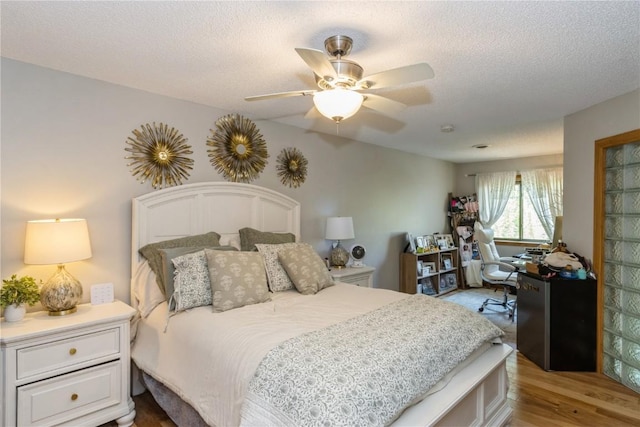1932 N Ridge Dr, Coralville, IA 52241 - bedroom with wood finished floors, a textured ceiling, refrigerator, and ceiling fan