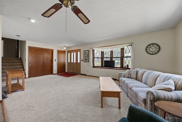 105 Parkview Dr, Tipton, IA 52772 - carpeted living room featuring ceiling fan, stairway, and a textured ceiling