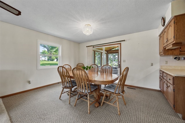 105 Parkview Dr, Tipton, IA 52772 - dining space featuring light colored carpet, a chandelier, and a textured ceiling