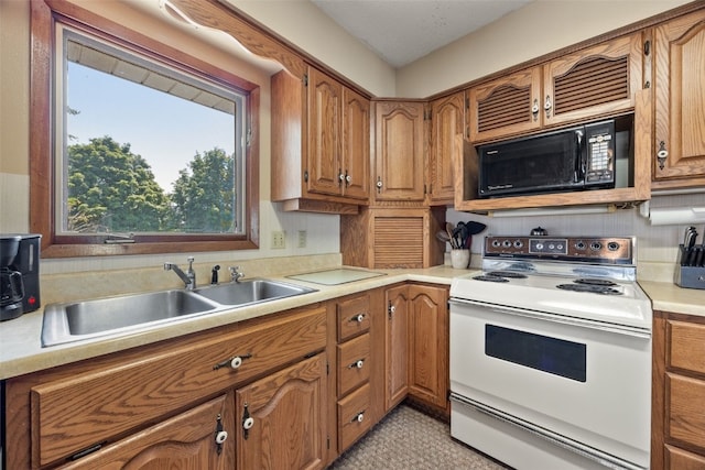 105 Parkview Dr, Tipton, IA 52772 - kitchen with white range with electric cooktop, black microwave, brown cabinets, and light countertops