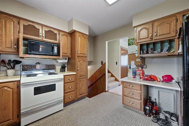 105 Parkview Dr, Tipton, IA 52772 - kitchen featuring white electric range, black microwave, light countertops, and brown cabinetry