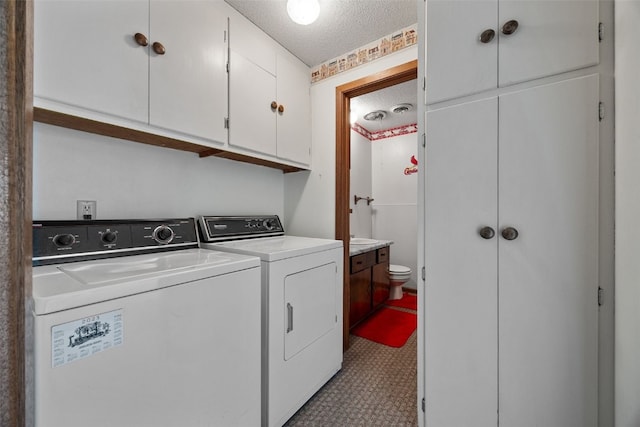 105 Parkview Dr, Tipton, IA 52772 - laundry area featuring a textured ceiling, washing machine and clothes dryer, and cabinet space