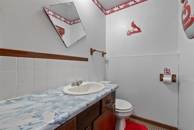 105 Parkview Dr, Tipton, IA 52772 - half bathroom featuring vanity, decorative backsplash, and a wainscoted wall