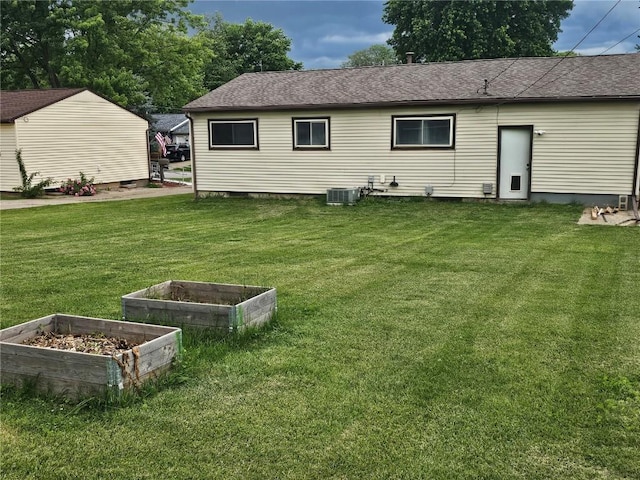 1523 Golden Valley Dr, Bettendorf, IA 52722 - back of property with a lawn, a vegetable garden, crawl space, and a shingled roof