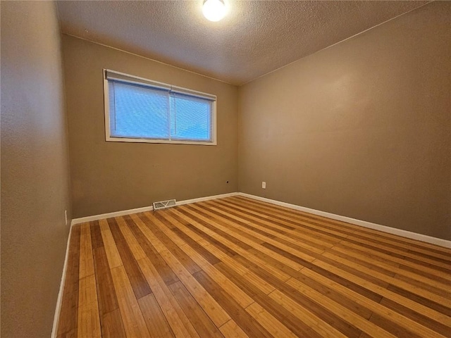 1523 Golden Valley Dr, Bettendorf, IA 52722 - unfurnished room with a textured ceiling and hardwood / wood-style flooring
