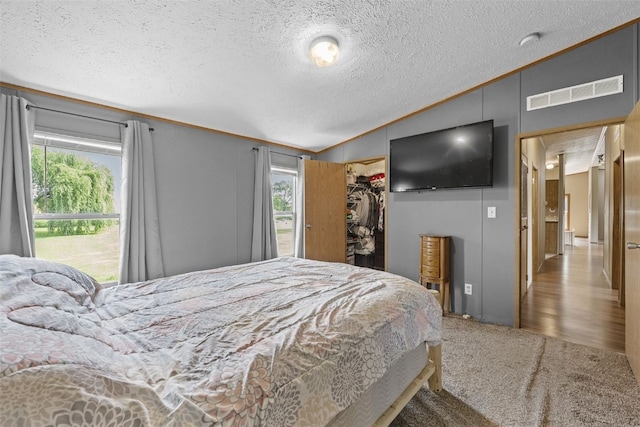 3017 118th St, Amana, IA 52203 - bedroom with vaulted ceiling, a textured ceiling, a spacious closet, ornamental molding, and carpet flooring