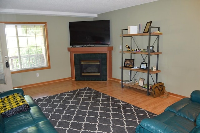 454 W Side Dr, Iowa City, IA 52245 - living room with wood finished floors, a tiled fireplace, and a textured ceiling