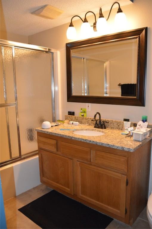 454 W Side Dr, Iowa City, IA 52245 - full bathroom featuring vanity and combined bath / shower with glass door