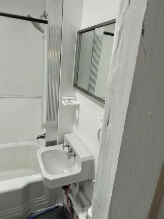 1402 N St SW, Cedar Rapids, IA 52404 - bathroom with washtub / shower combination and a sink