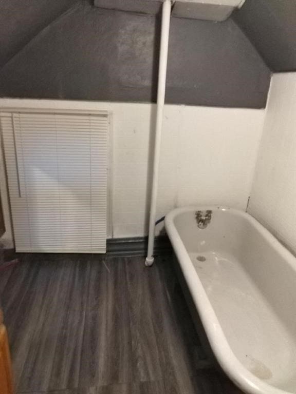 1402 N St SW, Cedar Rapids, IA 52404 - full bath with a freestanding bath, wood finished floors, and vaulted ceiling