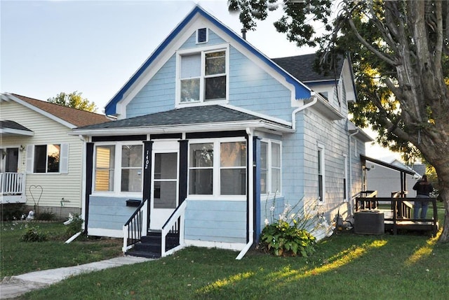 1402 N St SW, Cedar Rapids, IA 52404 - view of front facade with a shingled roof, a front lawn, entry steps, and a sunroom