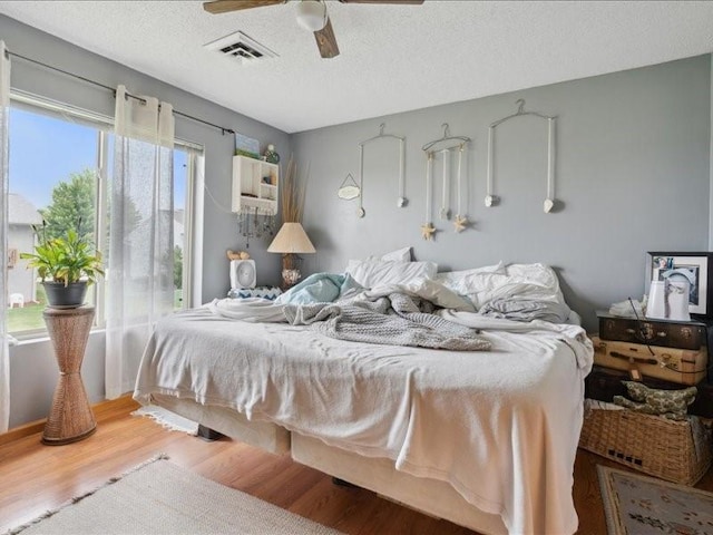 1020 240th St NE Unit 8, North Liberty, IA 52317 - bedroom with wood finished floors, a textured ceiling, and ceiling fan
