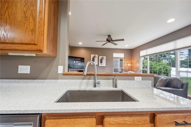 2385 Wolf Creek Trl, Hiawatha, IA 52233 - kitchen featuring brown cabinetry, light stone counters, recessed lighting, open floor plan, and stainless steel dishwasher