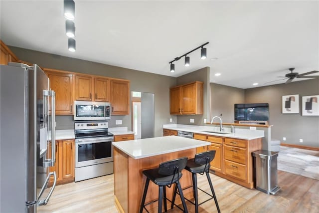 2385 Wolf Creek Trl, Hiawatha, IA 52233 - kitchen with stainless steel appliances, light countertops, a peninsula, and light wood-style flooring
