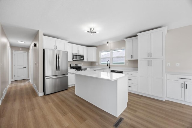 6612 Boulder Dr, Cedar Rapids, IA 52405 - kitchen with appliances with stainless steel finishes, light wood finished floors, light countertops, and white cabinetry