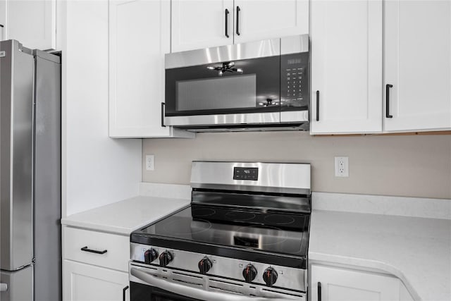 6612 Boulder Dr, Cedar Rapids, IA 52405 - kitchen with appliances with stainless steel finishes, light countertops, and white cabinetry