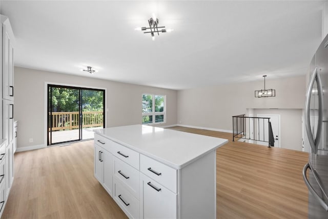 6612 Boulder Dr, Cedar Rapids, IA 52405 - kitchen with freestanding refrigerator, light wood finished floors, a center island, light countertops, and open floor plan