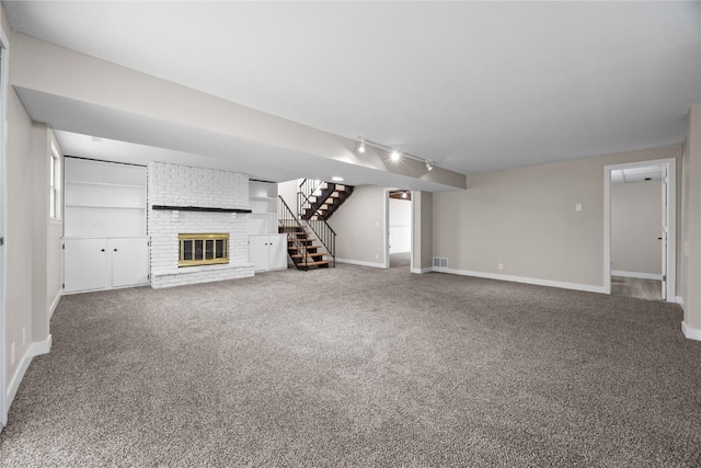 6612 Boulder Dr, Cedar Rapids, IA 52405 - unfurnished living room with track lighting, stairway, carpet floors, and a fireplace