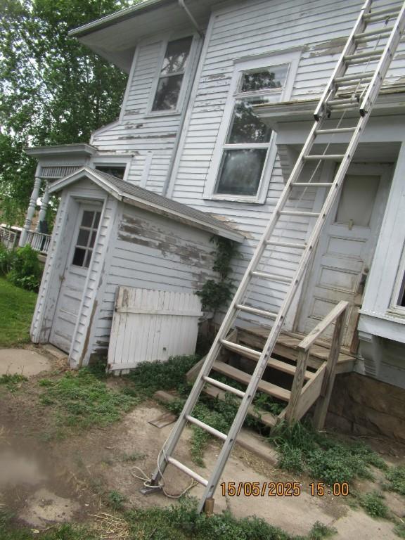 606 Meridian St, Tipton, IA 52772 - back of property featuring stairway and a shed