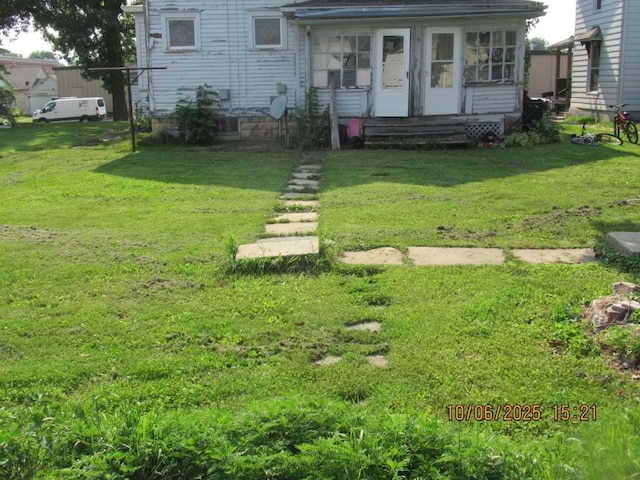 606 Meridian St, Tipton, IA 52772 - view of front facade with a sunroom and a front lawn