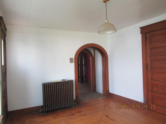 606 Meridian St, Tipton, IA 52772 - empty room featuring radiator and arched walkways