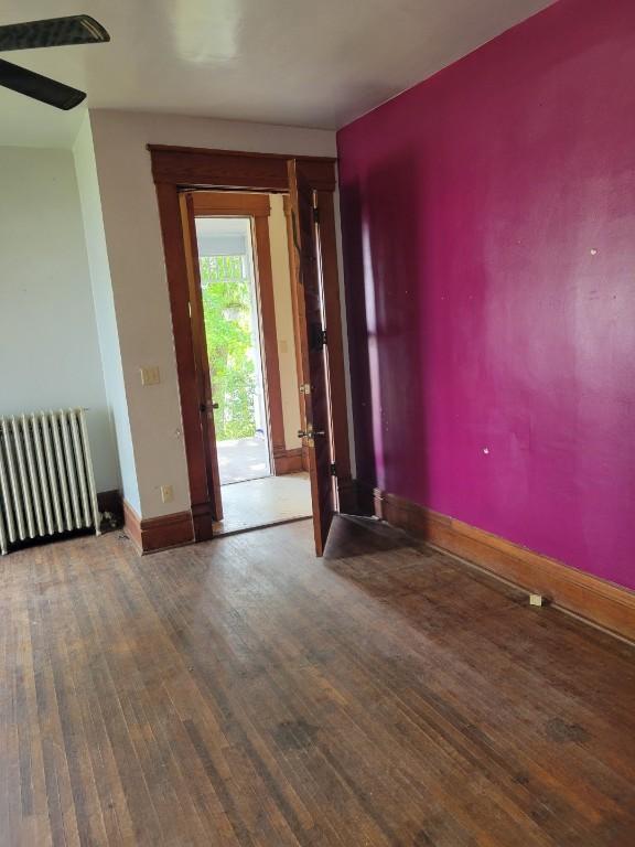 606 Meridian St, Tipton, IA 52772 - spare room featuring radiator and hardwood / wood-style floors
