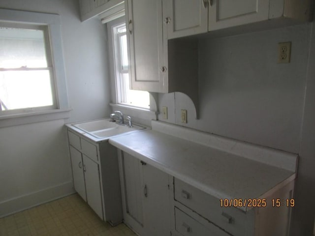 606 Meridian St, Tipton, IA 52772 - kitchen featuring plenty of natural light, white cabinets, light floors, and light countertops